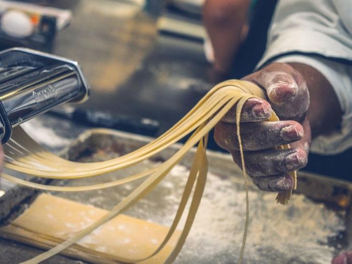 Trabajador elaborando pasta artesanal y cortándola